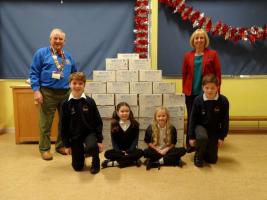 Headmistress Suzanne Lane and our club President John Hicks are pictured with four of the many school children who packed shoeboxes.